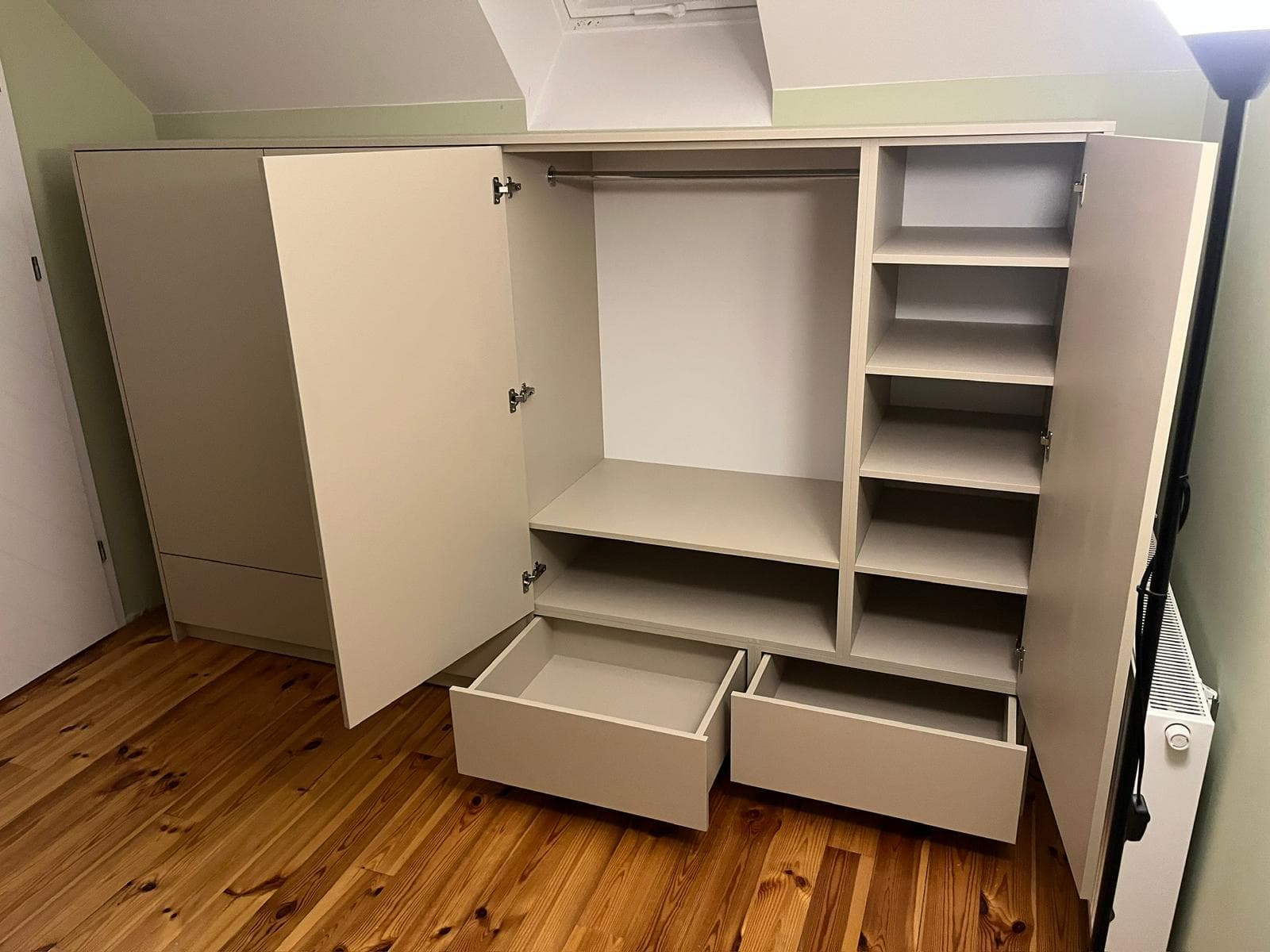 Szafa pod skosem z wieszakiem, półkami i wysuwnymi szufladami na poddaszu